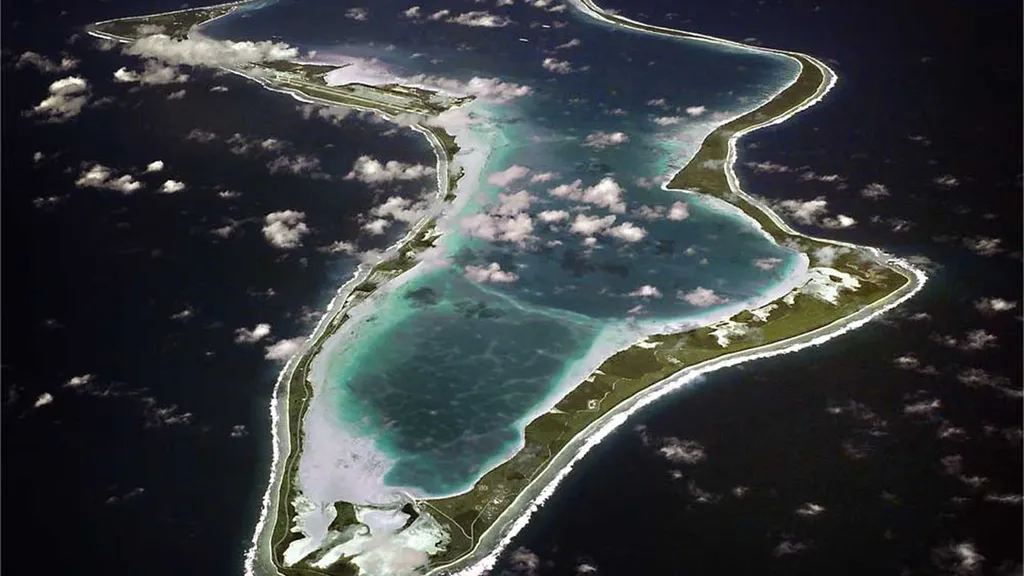 Aerial view of Diego Garcia atoll in the Chagos Islands, with the joint UK-US military base runway visible along the western arm.