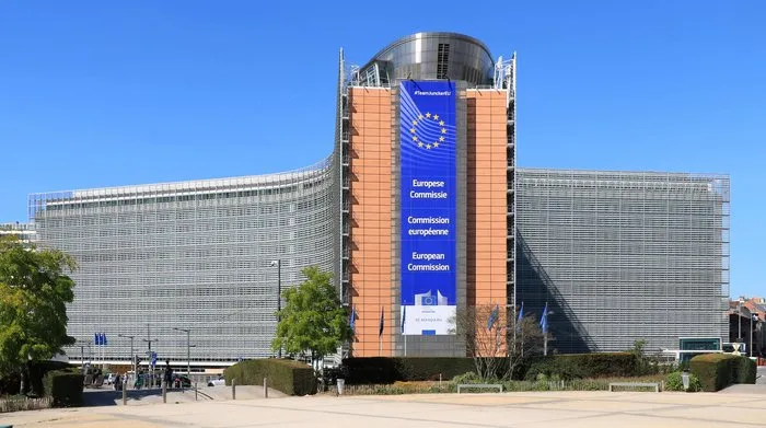 The Berlaymont building in Brussels, seat of the European Commission, with EU flags flying in the foreground