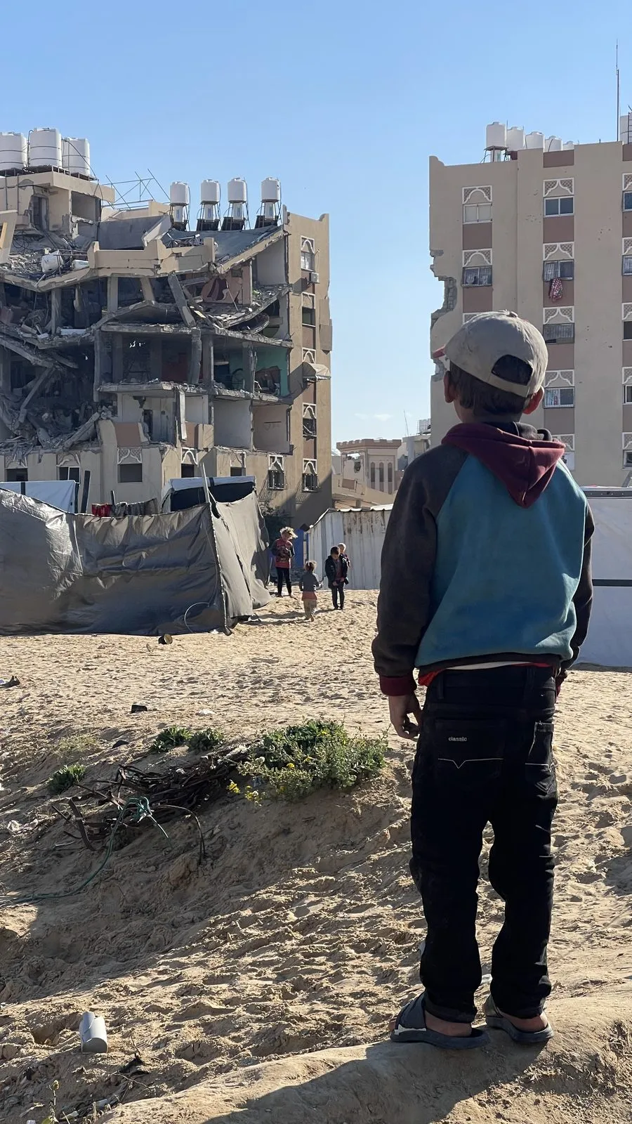 A Gazan child looks at war-destroyed buildings in Gaza