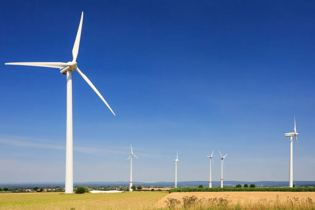 Wind turbines on a ridge above a road at a wind farm near Paderborn, Germany.