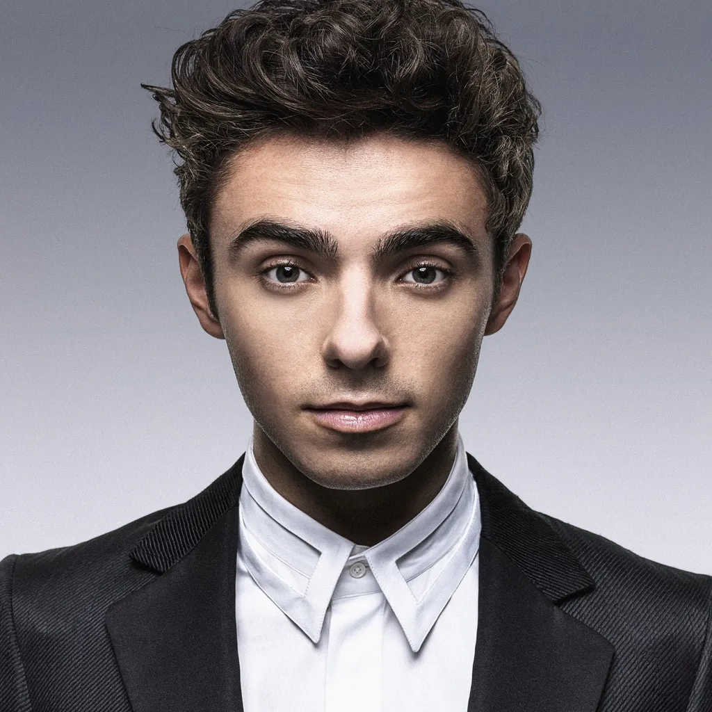 Nathan Sykes, singer of The Wanted, in a portrait photograph wearing a brown leather jacket.