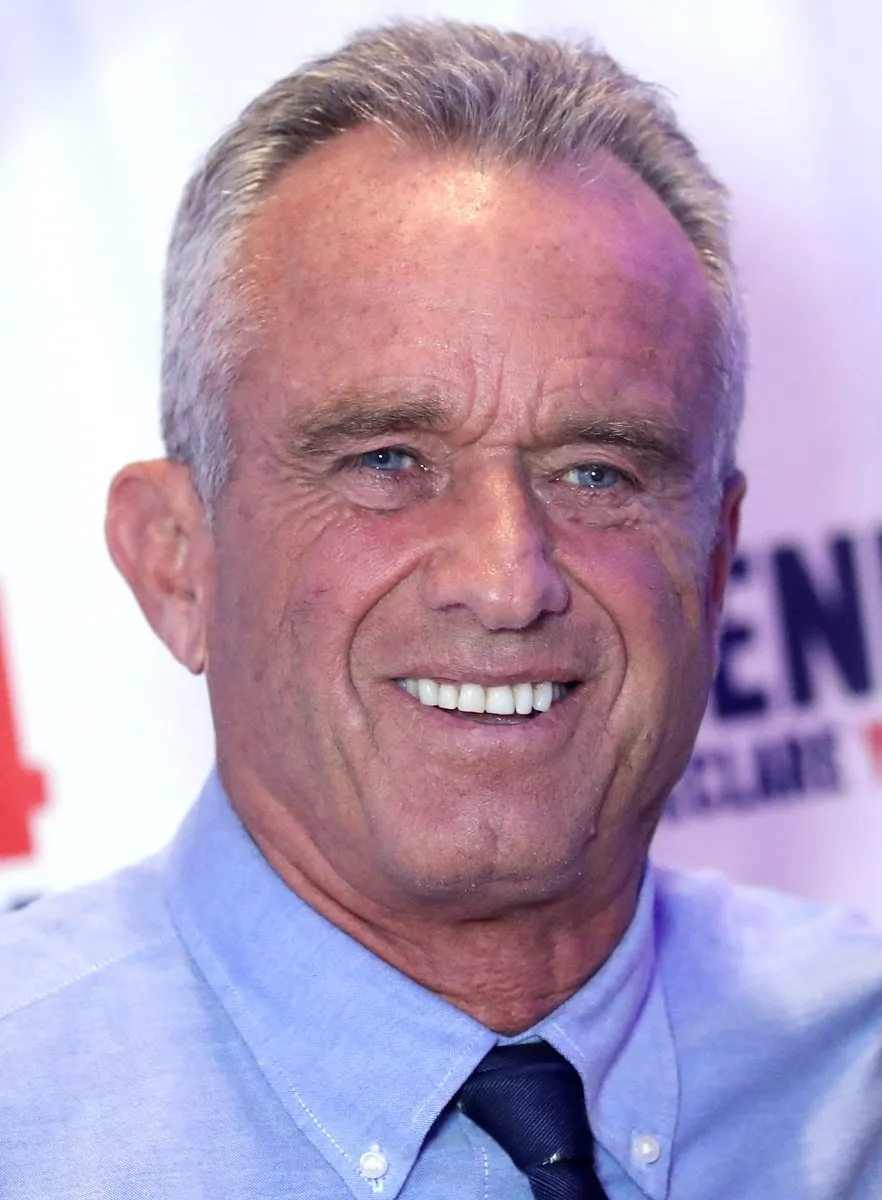 Robert F. Kennedy Jr. smiling at a speaking event in December 2023, wearing a light blue shirt and dark tie.