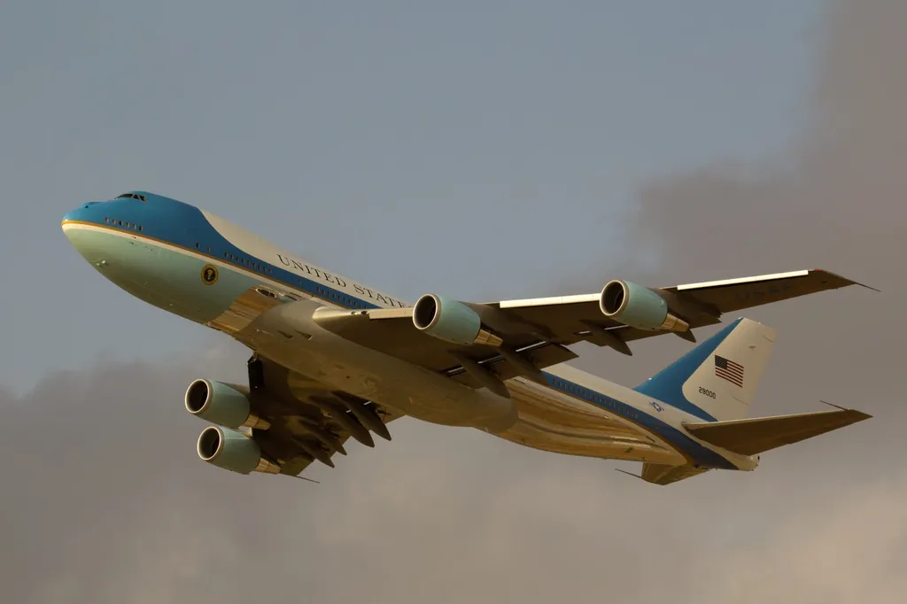Air Force One, the US presidential aircraft, in flight, showing its blue and white livery and the United States of America titles.