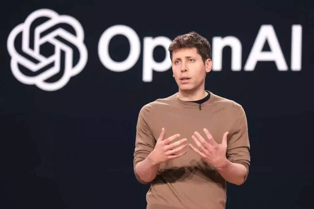 OpenAI CEO Sam Altman speaking at an event with the OpenAI logo behind him