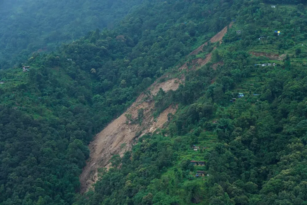Officials inspect the landslide-scarred Rimbi-Singlitam area in Sikkim's Gyalshing district, with mud and debris covering the slope (file photo, August 2026)