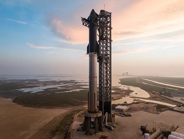 A SpaceX Starship stacked on the launch mount at Starbase, Texas, at dawn.
