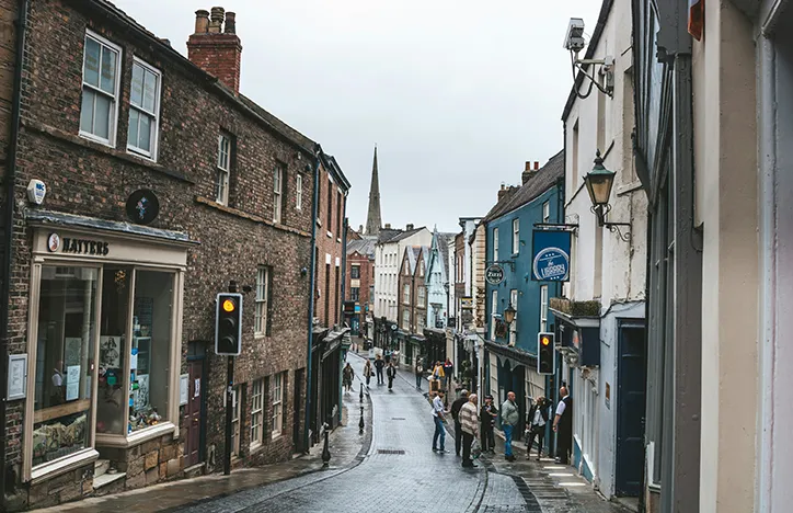 A traditional British high street with shops, cafes and pedestrians.