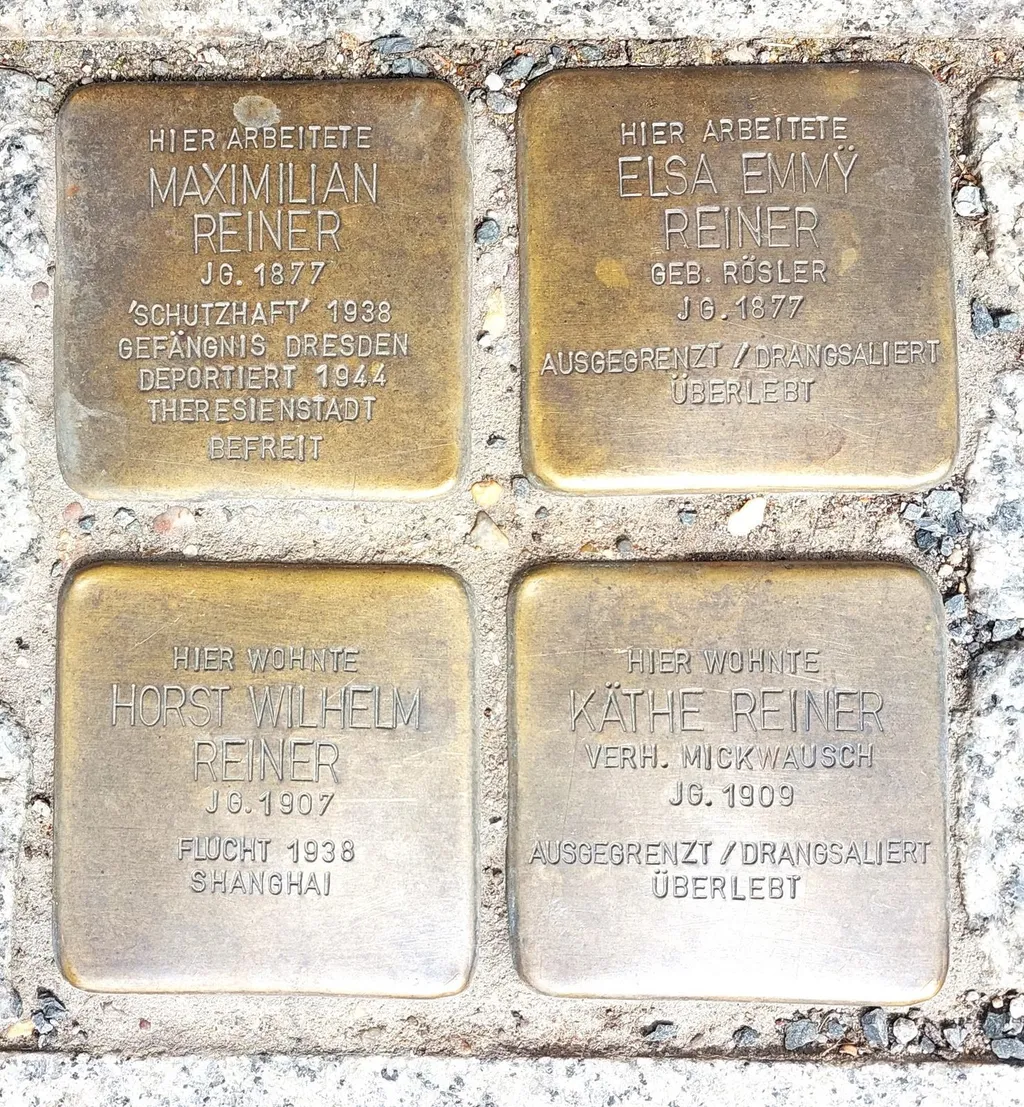 Four brass Stolpersteine memorial plaques set into the pavement in Heidenau, Germany, honouring members of the Reiner family.