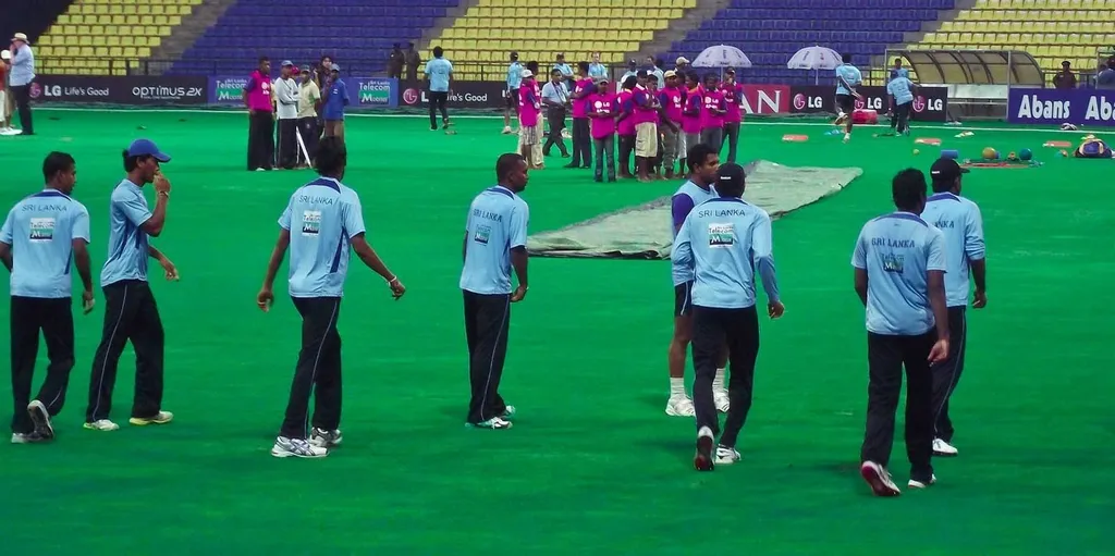 Sri Lanka's national cricket team practising in light-blue kit on a cricket field, with covers visible on the pitch