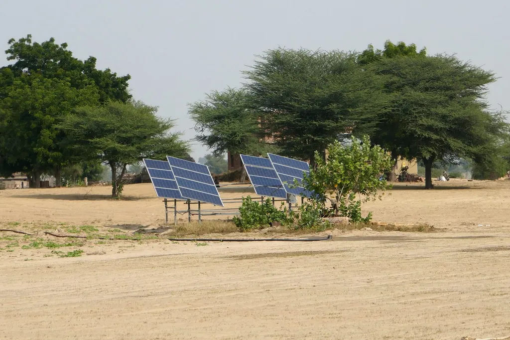 Solar panels at an Indian solar farm under a clear sky