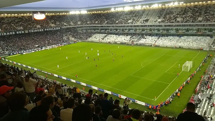 Interior of Bordeaux's Stade Atlantique during a match, with the packed Virage Sud stand and Matmut advertising boards visible