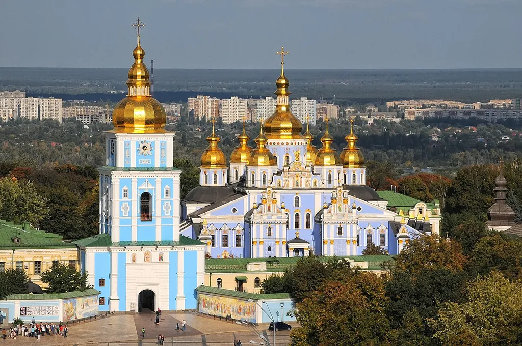 St Michael's Golden-Domed Monastery in Kyiv, Ukraine, with its golden domes and blue and white facades under a clear sky.