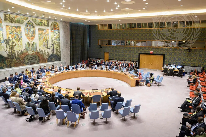 A wide view of the UN Security Council chamber in session, members seated around the horseshoe table