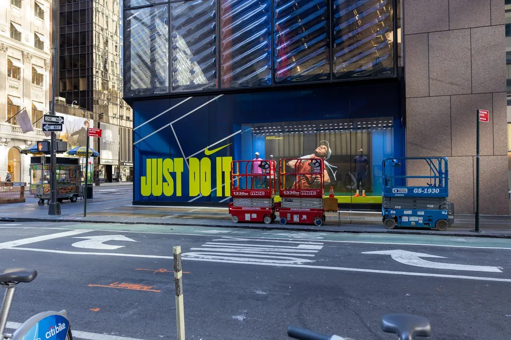 A Nike storefront in New York City with the company's swoosh logo on the building.