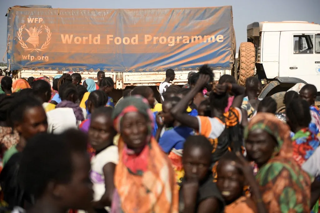 A World Food Programme aid truck surrounded by a crowd in Sudan