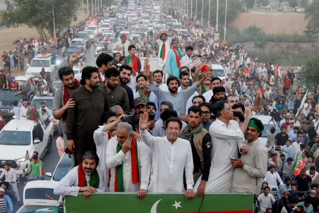 Imran Khan waves to supporters from a truck during a PTI long march