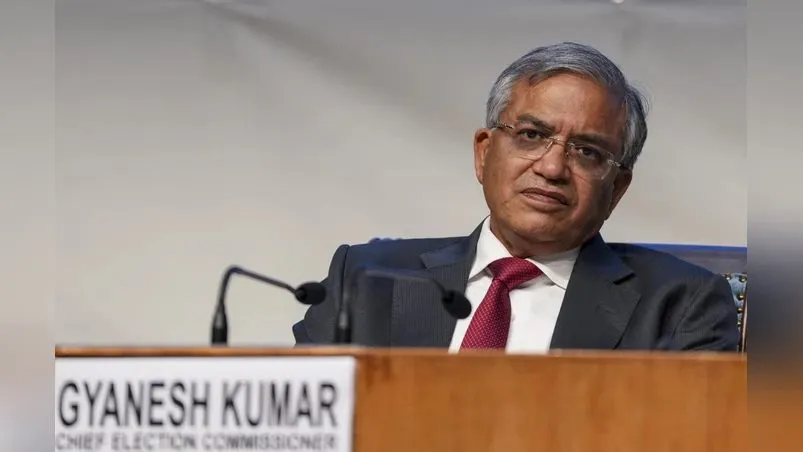 India's Chief Election Commissioner Gyanesh Kumar speaking at a podium with his nameplate