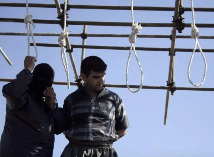 A prisoner stands on an execution scaffold with nooses in Iran