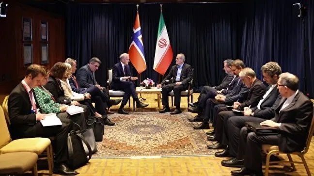 Iranian and Norwegian delegations meeting, with both countries' flags