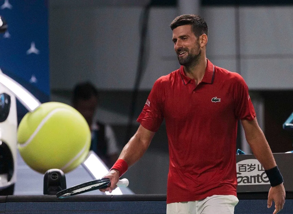 Novak Djokovic on court in China, holding his racket after a match