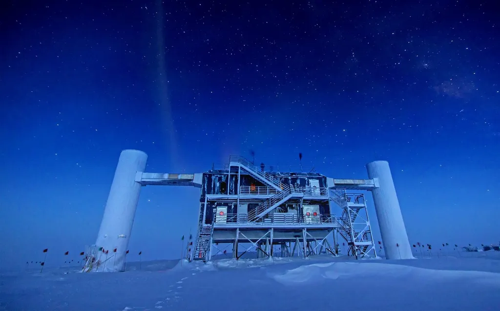 The IceCube Lab building at the South Pole under a starry night sky