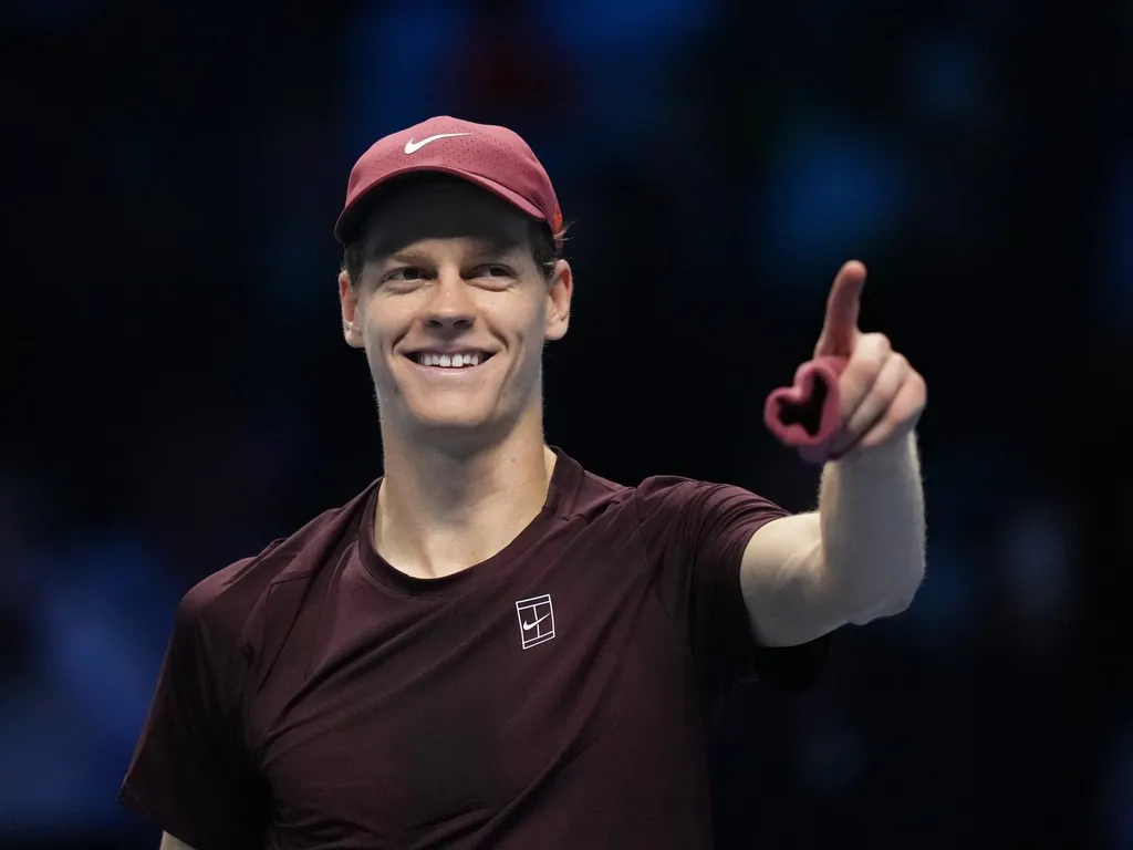 Jannik Sinner smiles and points to the crowd at the ATP Finals in Turin.