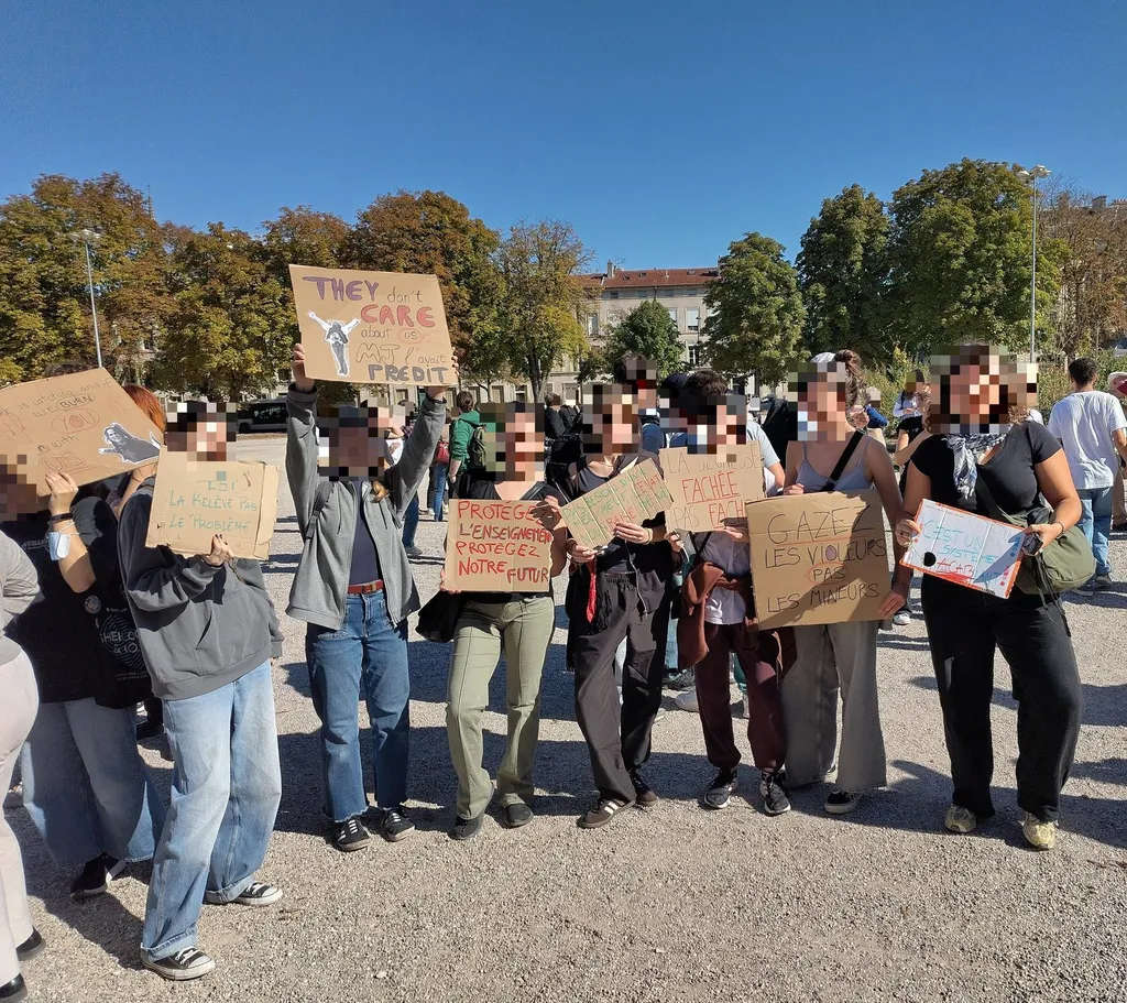 Student demonstrators holding hand-painted placards in Nancy, France, on 6 October 2026, with one sign reading "Protégez l'enseignement, protégez notre futur" (Protect education, protect our future).