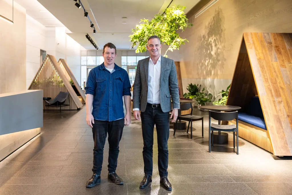 Reception area at Anthropic's San Francisco headquarters with triangular wooden seating pods and indoor plants, October 2024