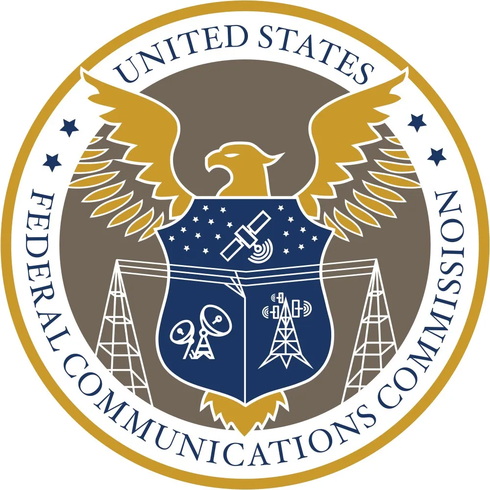 The official seal of the US Federal Communications Commission, an eagle with a shield bearing satellite, antenna and tower emblems