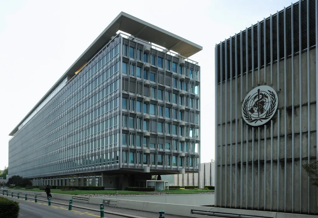 The World Health Organization headquarters in Geneva, a modern glass building bearing the WHO emblem.
