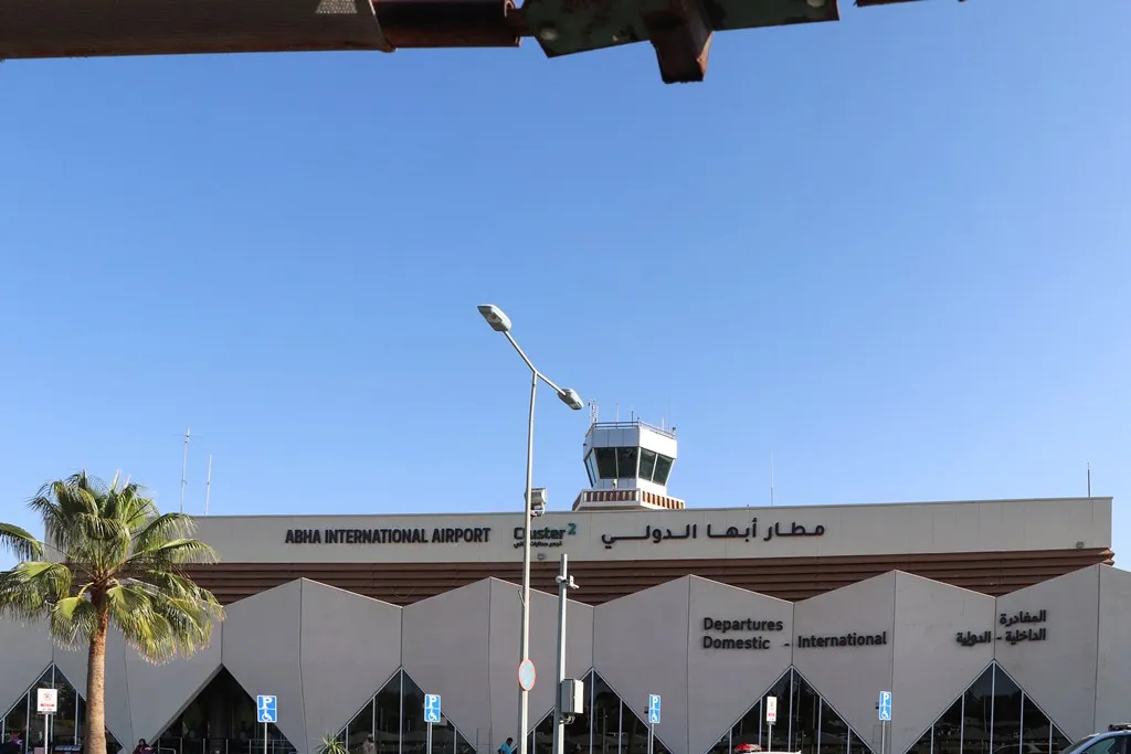 Abha International Airport terminal building with control tower under a clear sky
