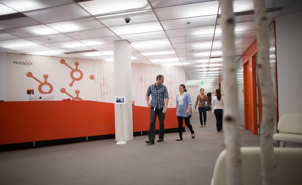 HubSpot's front lobby at its office, with the company's orange sprocket logo and wordmark on the reception wall.