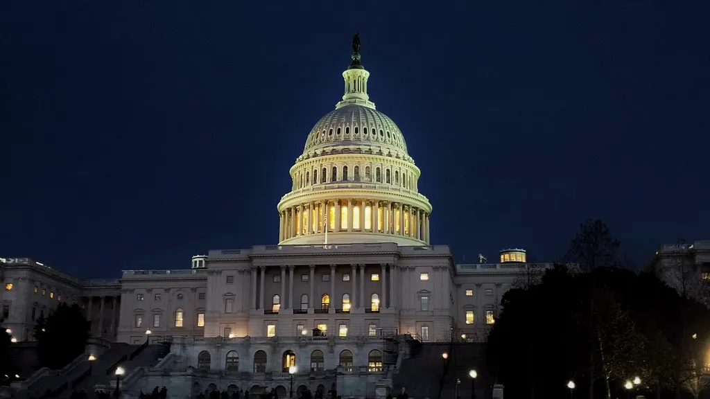 The US Capitol dome illuminated at night in Washington, DC.