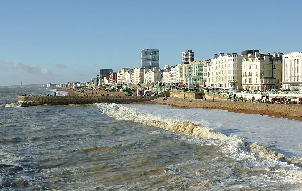 Waves breaking on Brighton beach with the seafront buildings and promenade behind