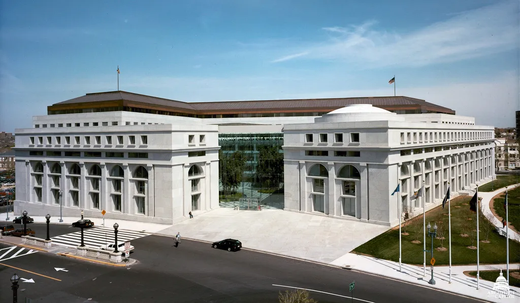 The Thurgood Marshall Federal Judiciary Building in Washington DC, headquarters of the Administrative Office of the US Courts, photographed from across Columbus Circle with its white-granite wings and glass atrium entrance.