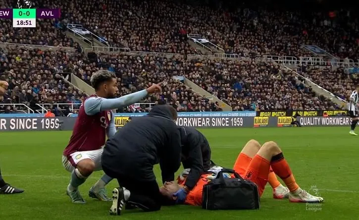 Emiliano Martinez receives medical treatment on the pitch after picking up an injury