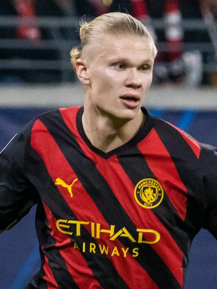 Erling Haaland in action for Manchester City, wearing the club's red-and-black away shirt.