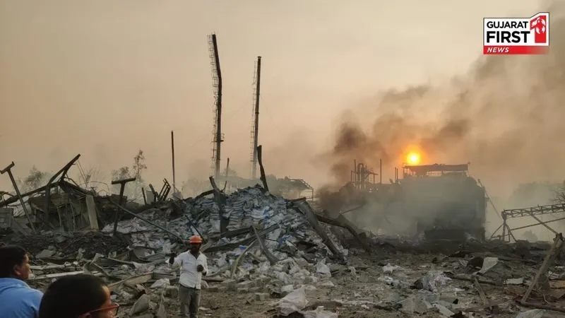 Smoke and fire rising from a blast-damaged chemical plant in Bharuch, Gujarat, with onlookers nearby