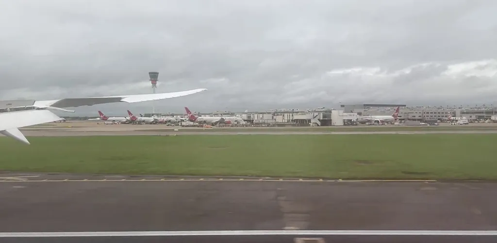 Heathrow Airport's control tower and Terminal 3, with Virgin Atlantic aircraft parked at the gates.