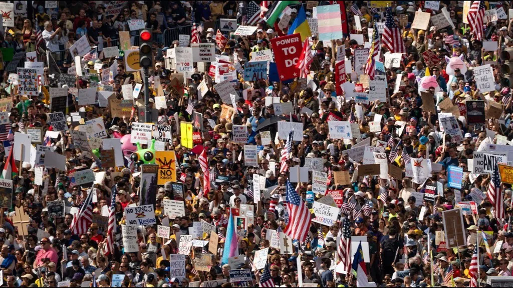 Thousands of 'No Kings' protesters fill a street with signs and flags