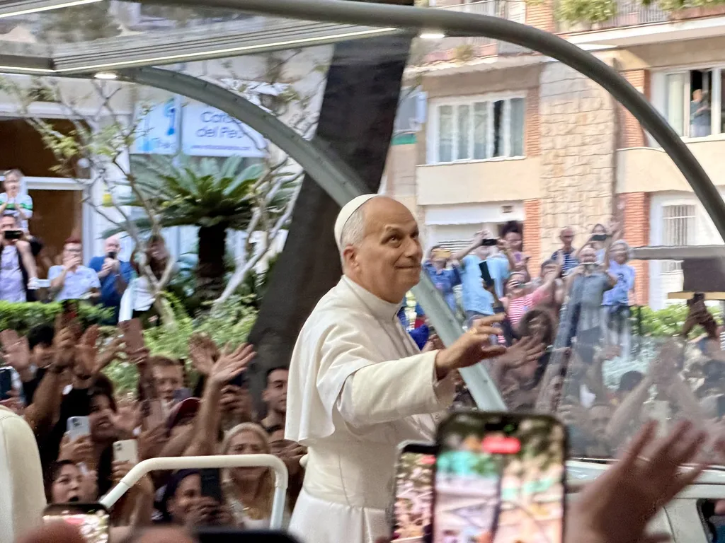 Pope Leo XIV in white papal dress waving to crowds from the popemobile in Barcelona, June 2026