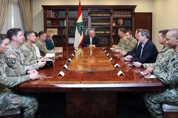Lebanese military officials meet around a conference table beneath the Lebanese flag