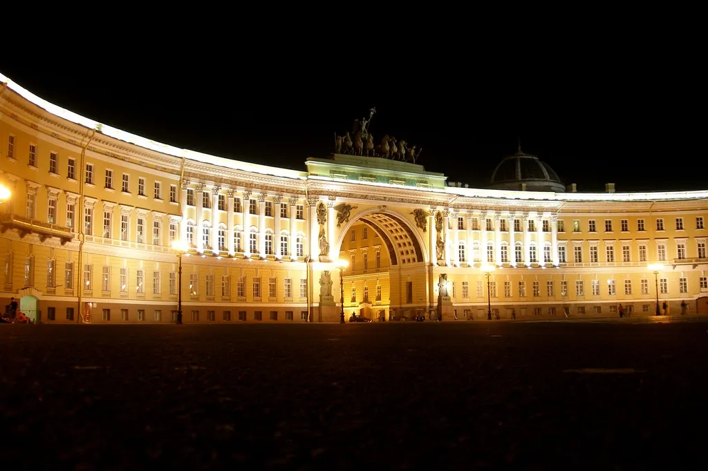 The illuminated triumphal arch of the General Staff Building on Palace Square, St Petersburg, at night.