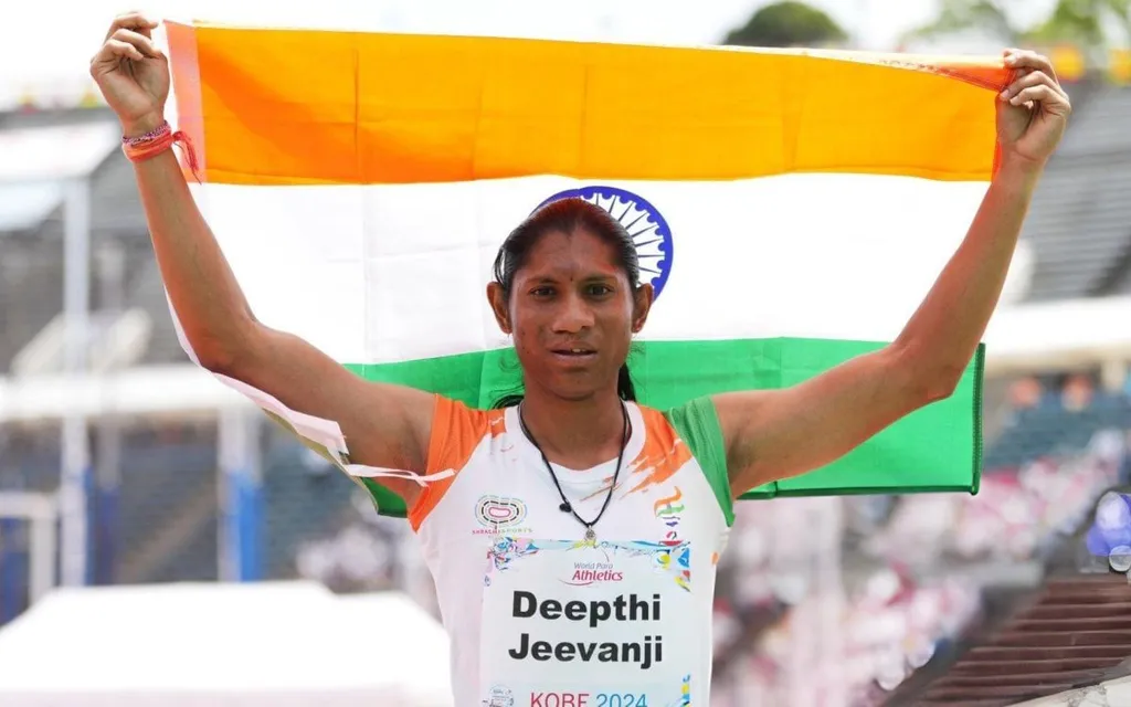 Deepthi Jeevanji holds the Indian flag aloft wearing her World Para Athletics Kobe 2024 race bib after winning 400m T20 gold