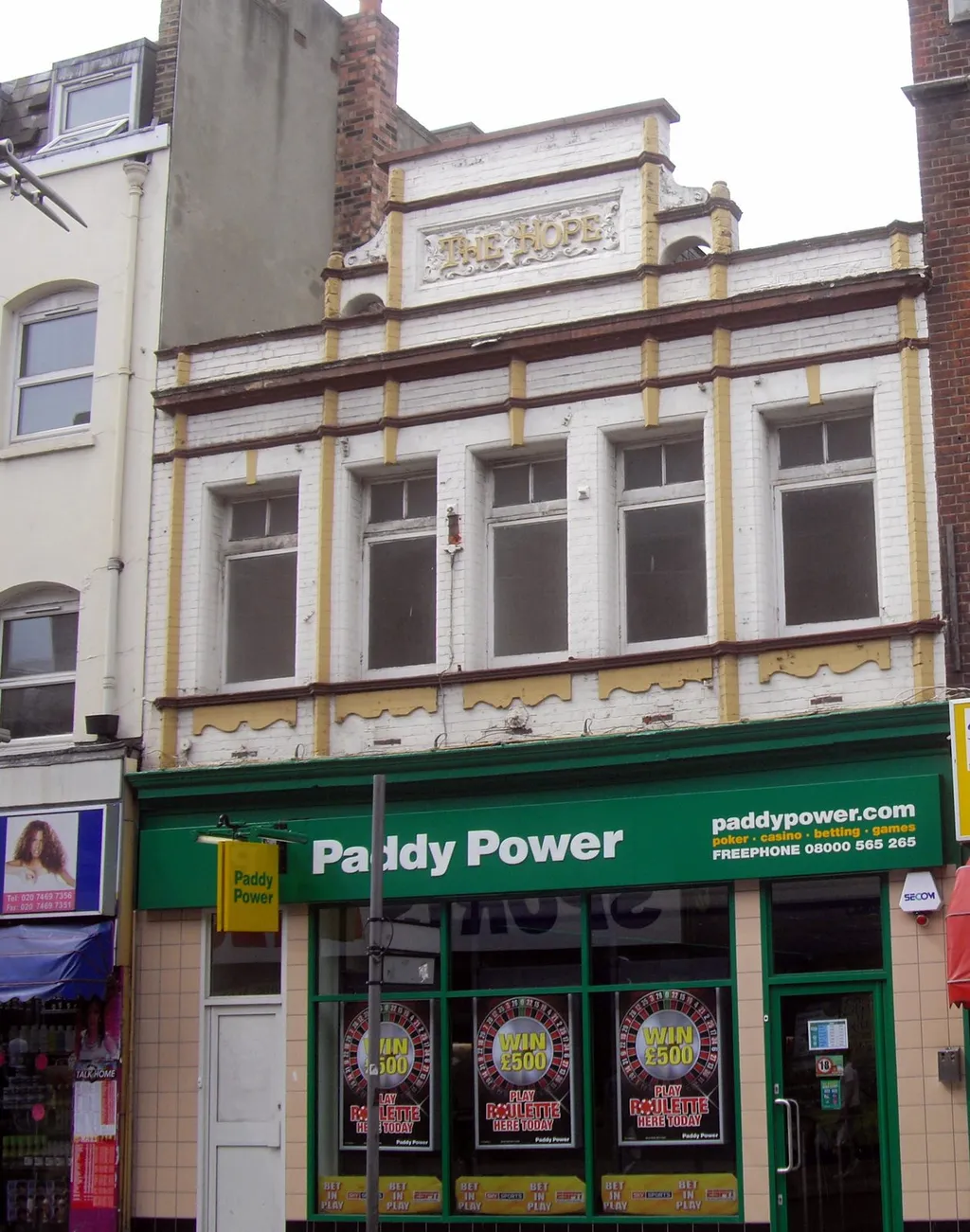 A Paddy Power betting shop on Rye Lane in Peckham, London, with the brand's green shopfront signage