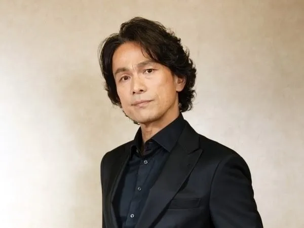 Portrait of Japanese voice actor Hiroshi Tsuchida in a dark suit