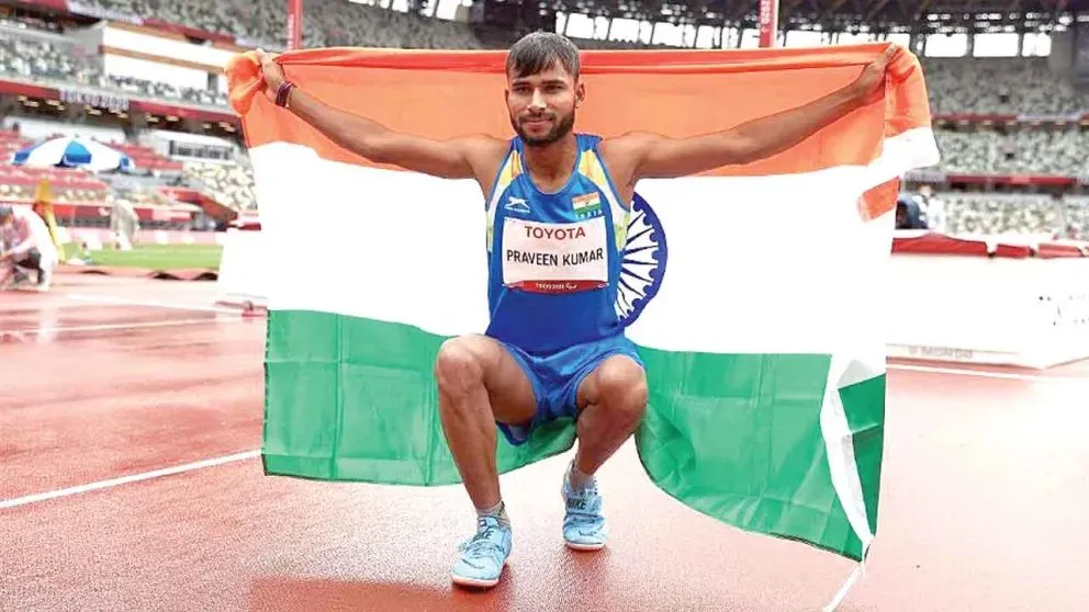 Praveen Kumar holding the Indian flag after a para athletics gold win