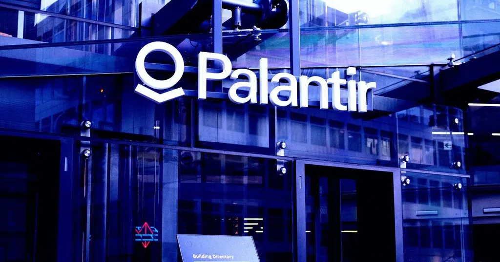 Palantir's logo displayed on the glass facade of a company building.