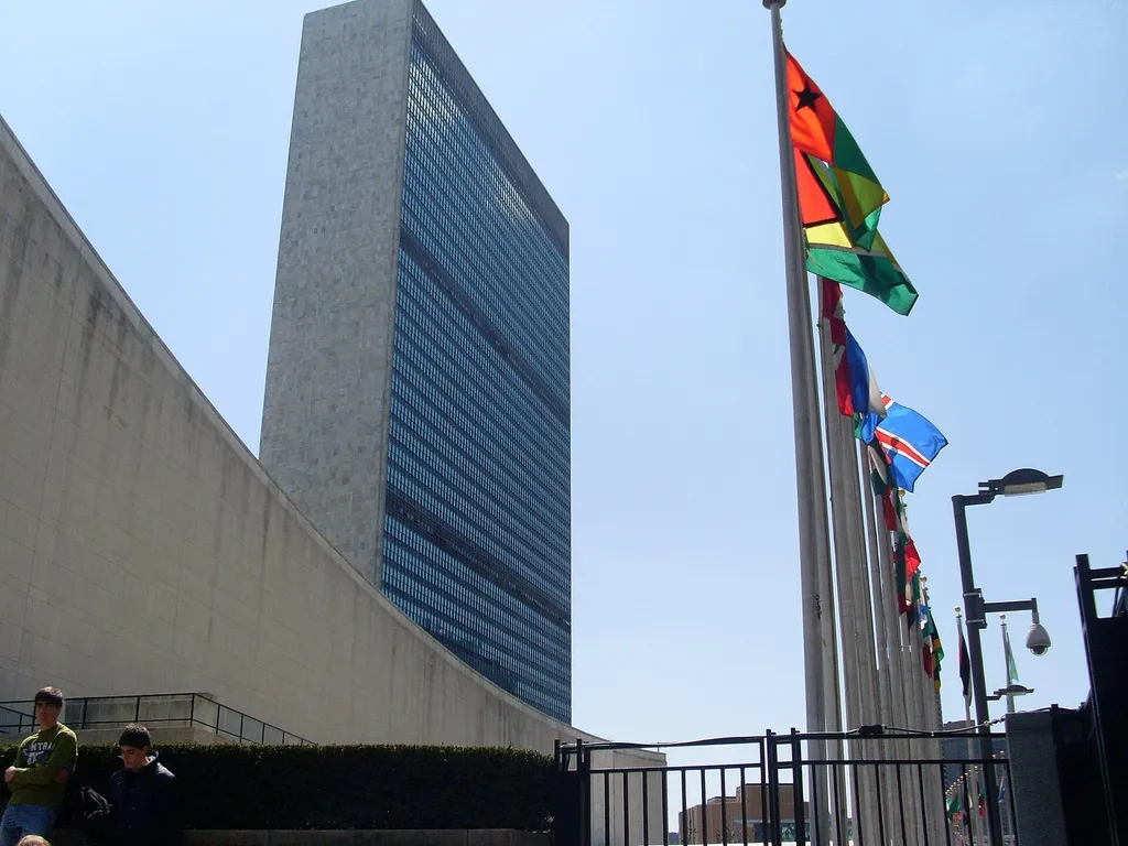 The United Nations headquarters in New York City, with the Secretariat tower and member-state flags.