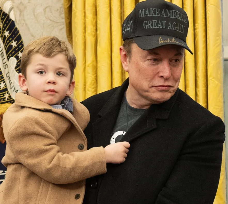 Elon Musk holding his young son in the Oval Office of the White House in February 2025